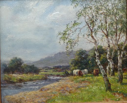 Cows grazing by a river
